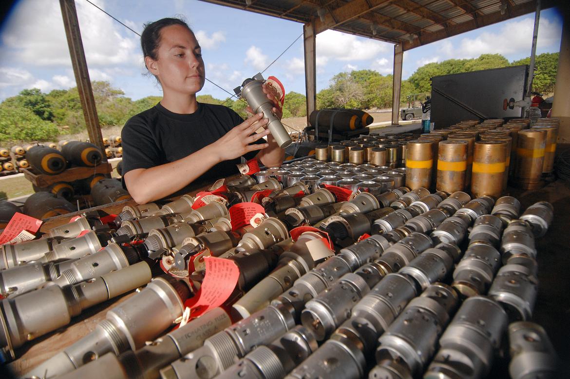 Airman inspects nose fuzes before inserting them into bombs for B-52.